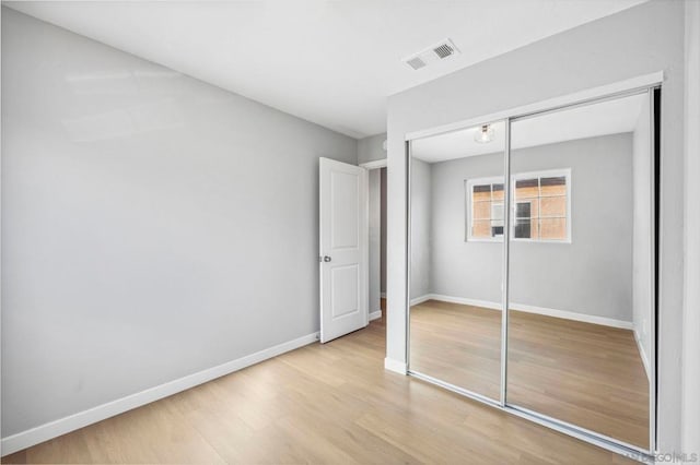 unfurnished bedroom with a closet and light hardwood / wood-style flooring