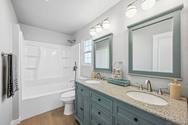 full bathroom featuring washtub / shower combination, hardwood / wood-style floors, toilet, and vanity