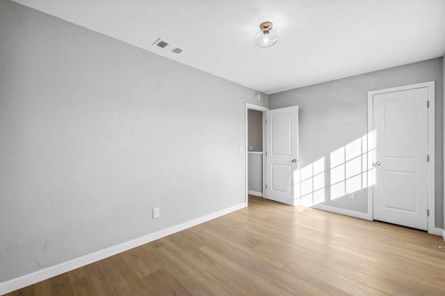 empty room with light hardwood / wood-style flooring