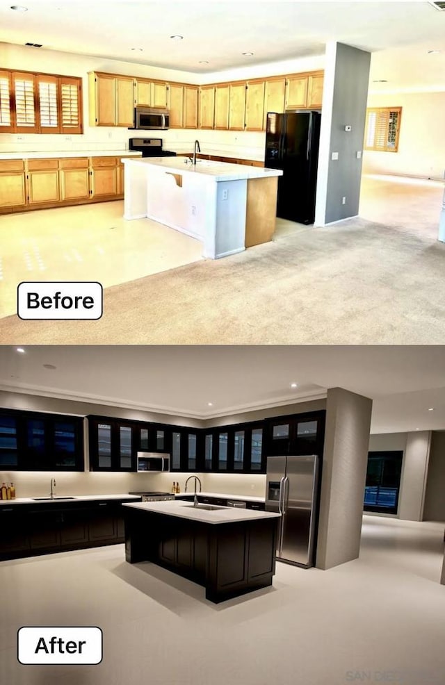 kitchen featuring appliances with stainless steel finishes, sink, a kitchen island with sink, and light brown cabinets