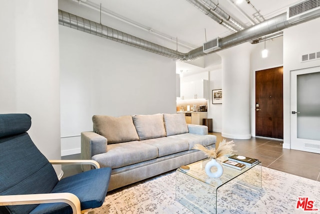 tiled living room with a towering ceiling