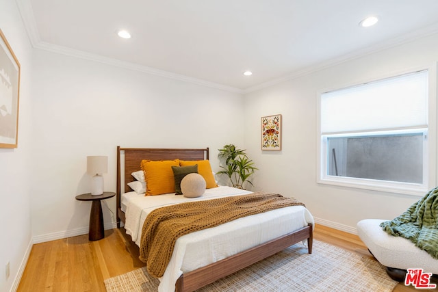 bedroom with hardwood / wood-style floors and crown molding