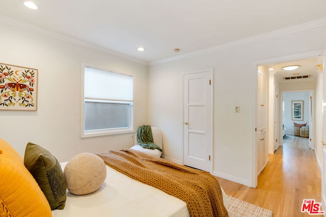 bedroom with light hardwood / wood-style flooring and ornamental molding