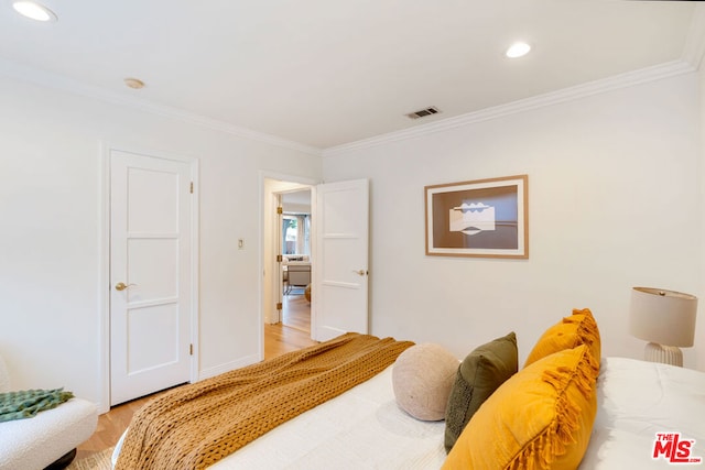 bedroom with light hardwood / wood-style floors and crown molding