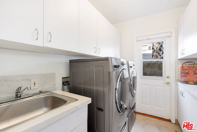 laundry area featuring sink, ornamental molding, cabinets, and independent washer and dryer