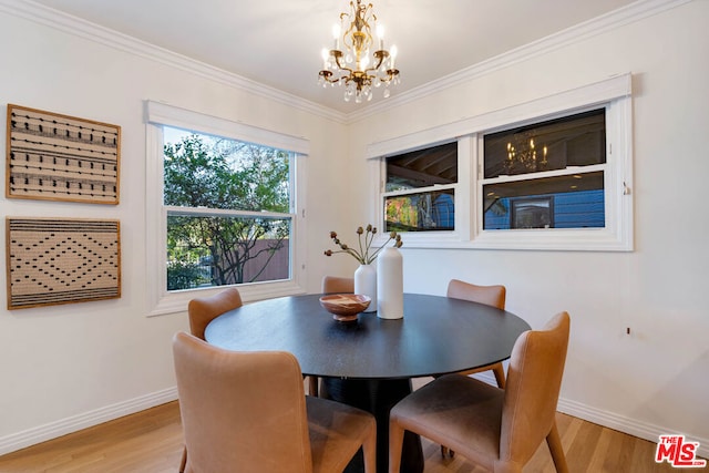 dining room with ornamental molding, a notable chandelier, and light wood-type flooring