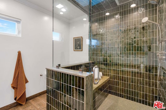 bathroom with hardwood / wood-style floors, tiled shower, and ornamental molding