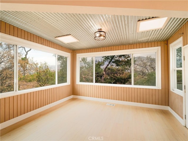 unfurnished sunroom featuring a healthy amount of sunlight and a skylight