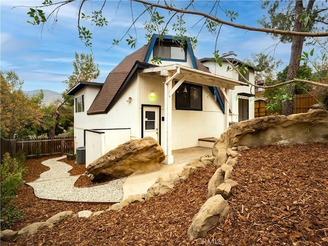 back of house with a mountain view and central AC unit