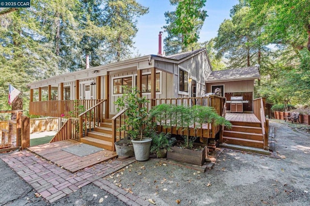 rear view of house featuring a deck and a sunroom