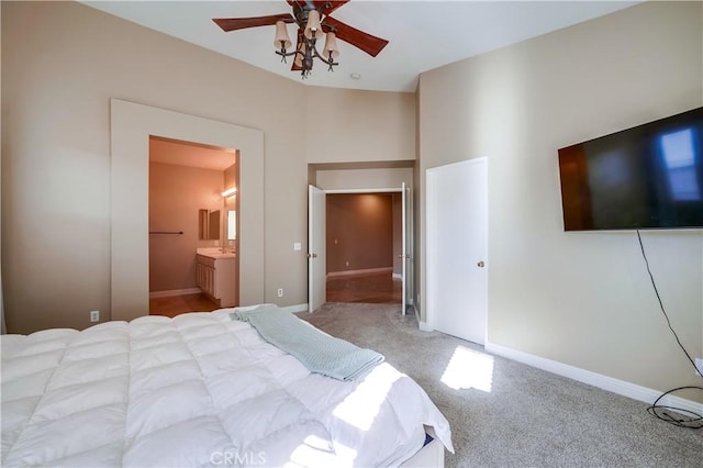 bedroom featuring ceiling fan, light colored carpet, and ensuite bath