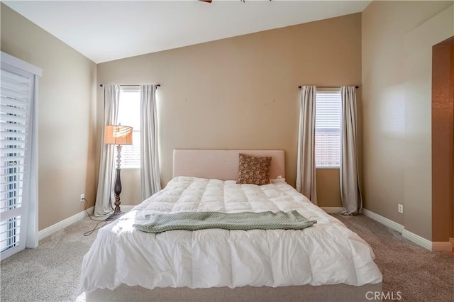 bedroom featuring multiple windows, light carpet, and lofted ceiling