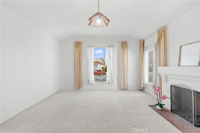 unfurnished living room featuring vaulted ceiling and carpet floors