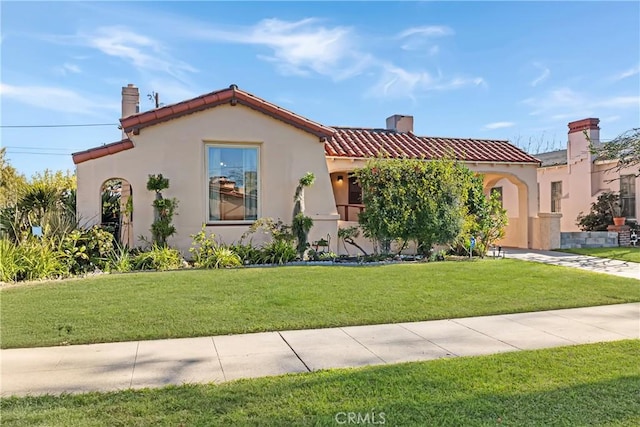 mediterranean / spanish house with a front lawn