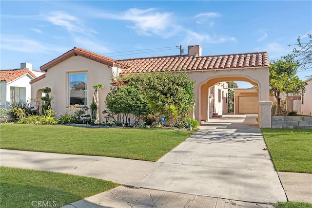 mediterranean / spanish home featuring a front yard and a garage