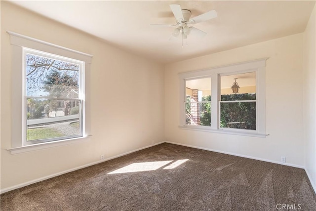 carpeted empty room with ceiling fan and plenty of natural light