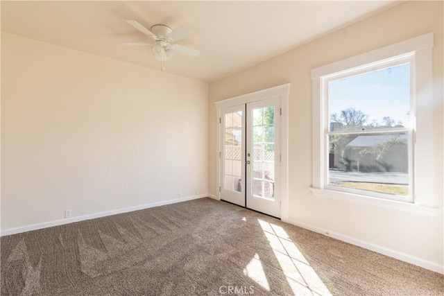 carpeted spare room with ceiling fan and french doors