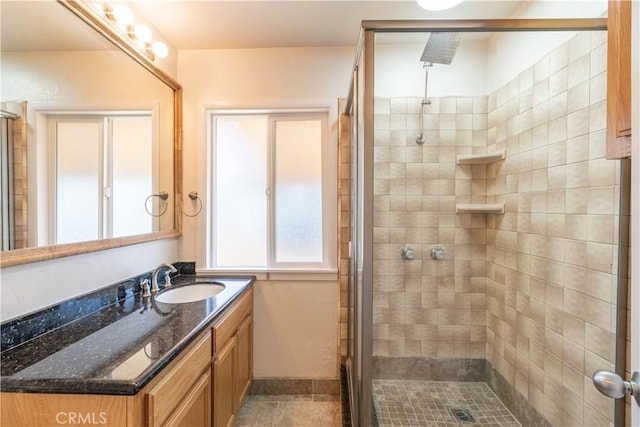 bathroom featuring a shower with shower door and vanity