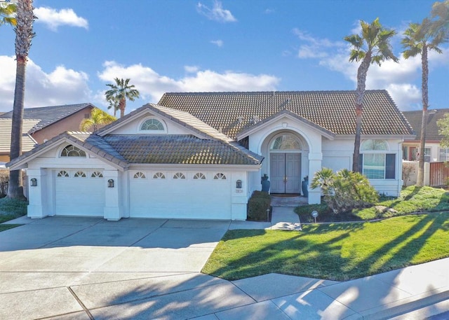 view of front of house featuring a garage and a front lawn