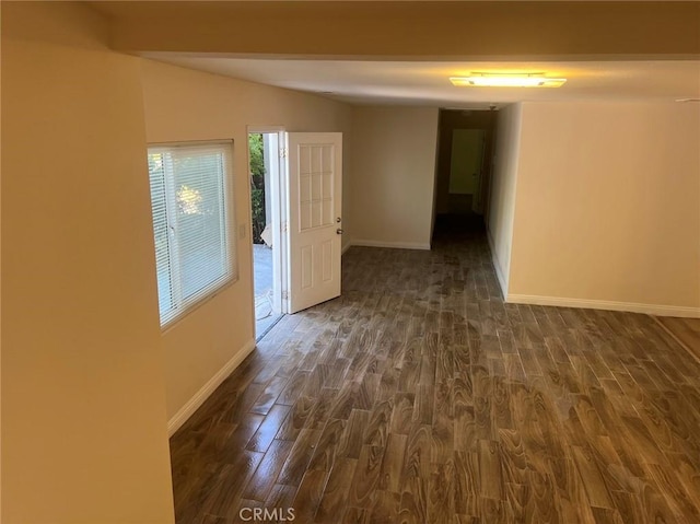 unfurnished room featuring vaulted ceiling and dark hardwood / wood-style flooring