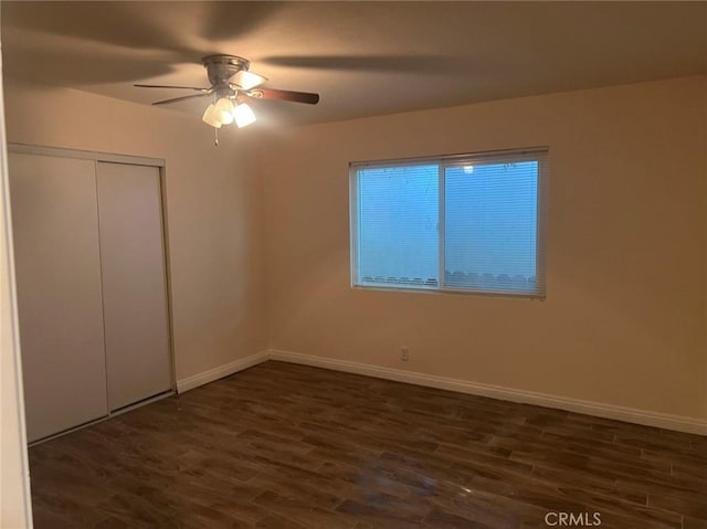 unfurnished bedroom with dark hardwood / wood-style flooring, a closet, and ceiling fan