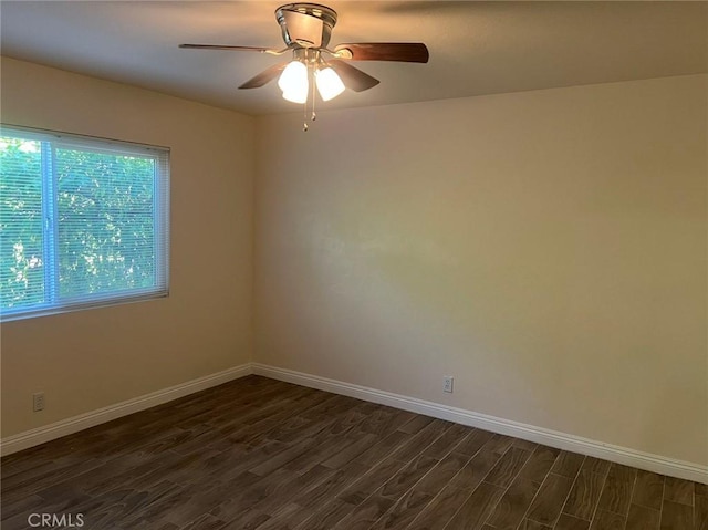 empty room with ceiling fan and dark hardwood / wood-style flooring