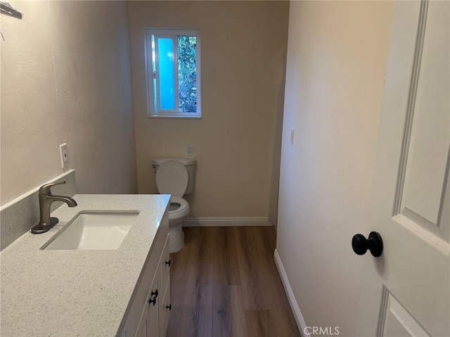 bathroom featuring hardwood / wood-style flooring, vanity, and toilet