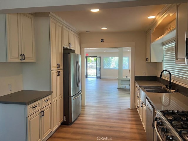 kitchen featuring appliances with stainless steel finishes, sink, and light hardwood / wood-style flooring