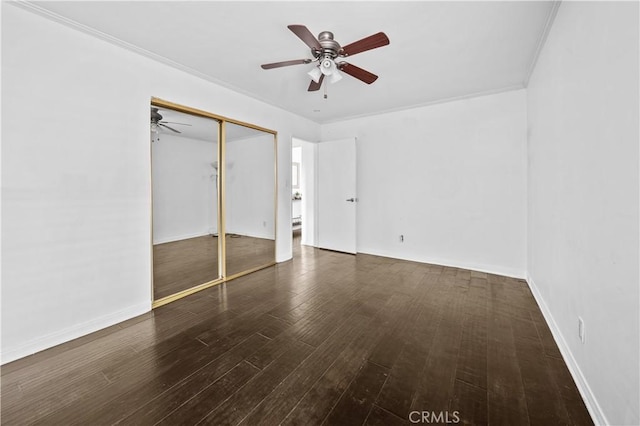 unfurnished bedroom featuring dark hardwood / wood-style flooring, ornamental molding, a closet, and ceiling fan