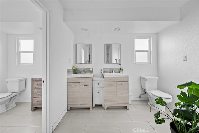 bathroom featuring vanity, plenty of natural light, and toilet