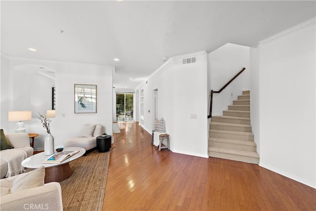 living room with hardwood / wood-style flooring and ornamental molding