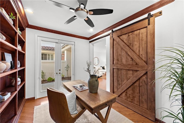 office featuring ornamental molding, french doors, light hardwood / wood-style floors, and a barn door