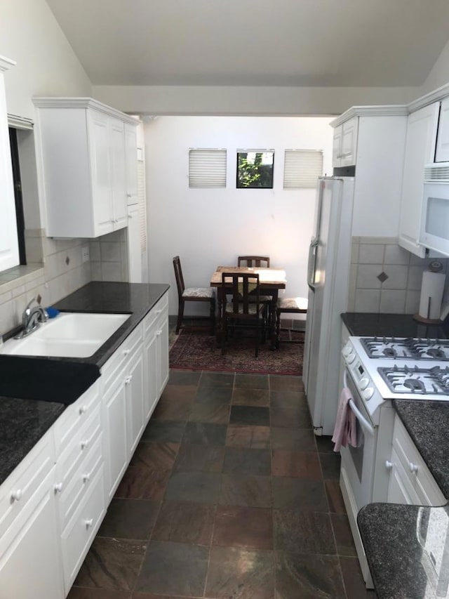 kitchen featuring sink, white cabinetry, and white appliances