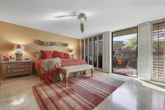 bedroom featuring access to exterior, expansive windows, and ceiling fan