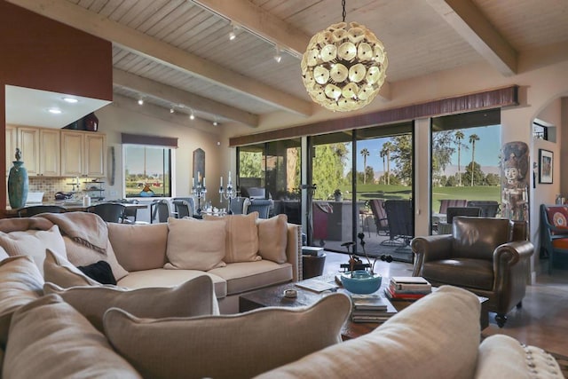 living room with track lighting, an inviting chandelier, and lofted ceiling with beams