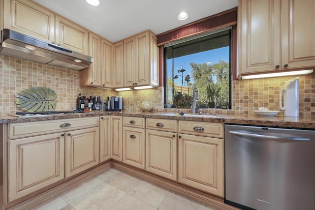 kitchen with sink, tasteful backsplash, dark stone counters, light tile patterned flooring, and stainless steel appliances