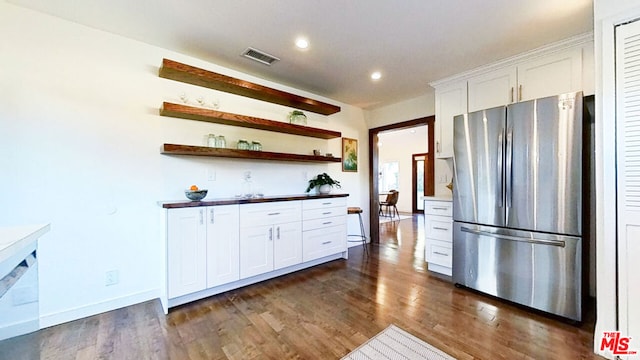 kitchen featuring white cabinets, dark hardwood / wood-style flooring, and stainless steel refrigerator