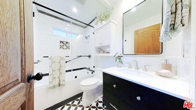 full bathroom featuring toilet, tiled shower / bath, tile patterned flooring, and vanity