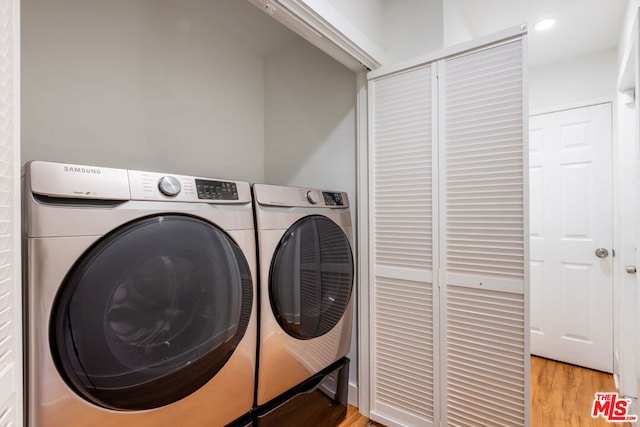 laundry area with light wood-type flooring and washer and dryer