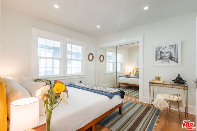 bedroom with hardwood / wood-style floors and a closet