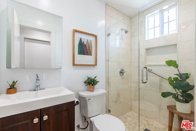 bathroom featuring toilet, an enclosed shower, and vanity