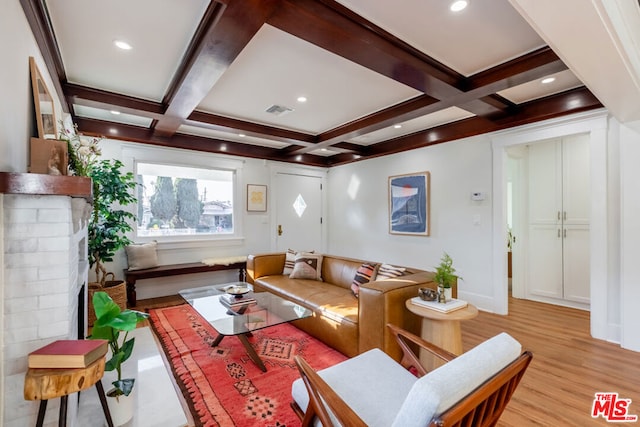 living room featuring coffered ceiling, light hardwood / wood-style floors, and beam ceiling