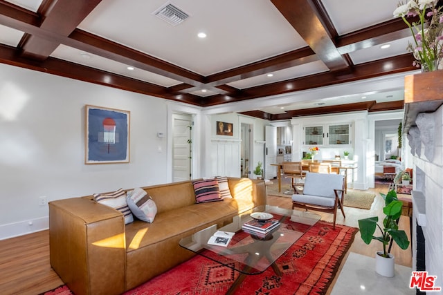 living room featuring coffered ceiling, beamed ceiling, and light hardwood / wood-style floors