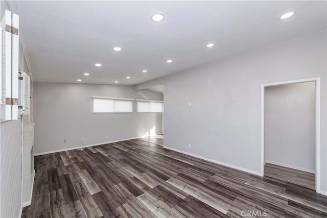 spare room with dark hardwood / wood-style flooring and vaulted ceiling