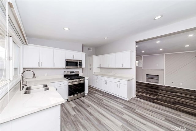 kitchen featuring light hardwood / wood-style floors, sink, white cabinetry, and stainless steel appliances