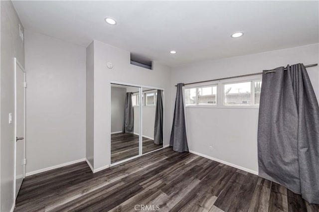 unfurnished bedroom featuring a closet and dark hardwood / wood-style flooring