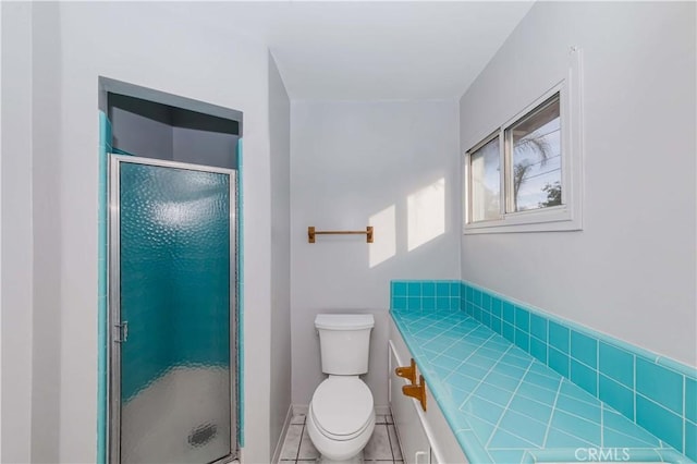 bathroom with toilet, tile patterned floors, and a shower with shower door