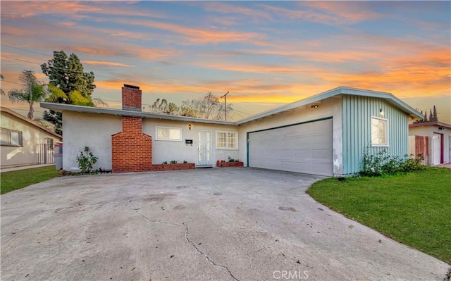 ranch-style house featuring a lawn and a garage