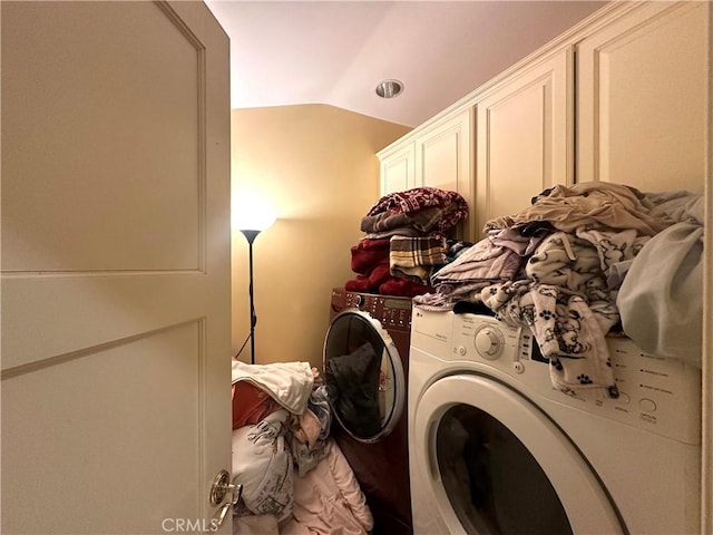 clothes washing area with cabinets and washer and dryer