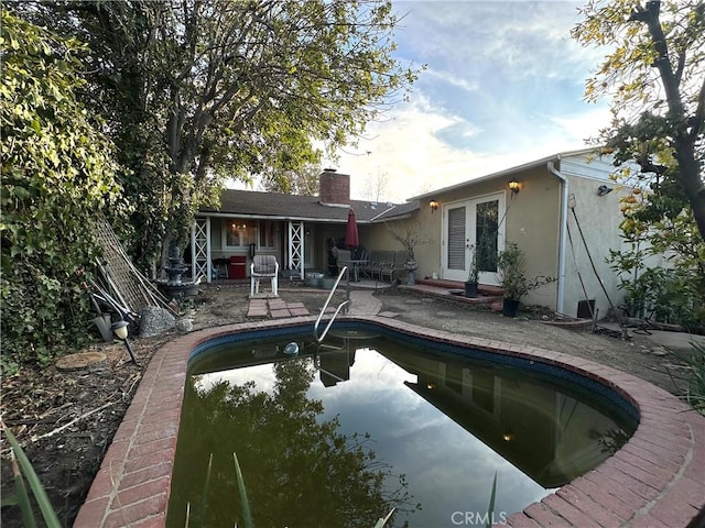 rear view of property featuring a patio area and french doors